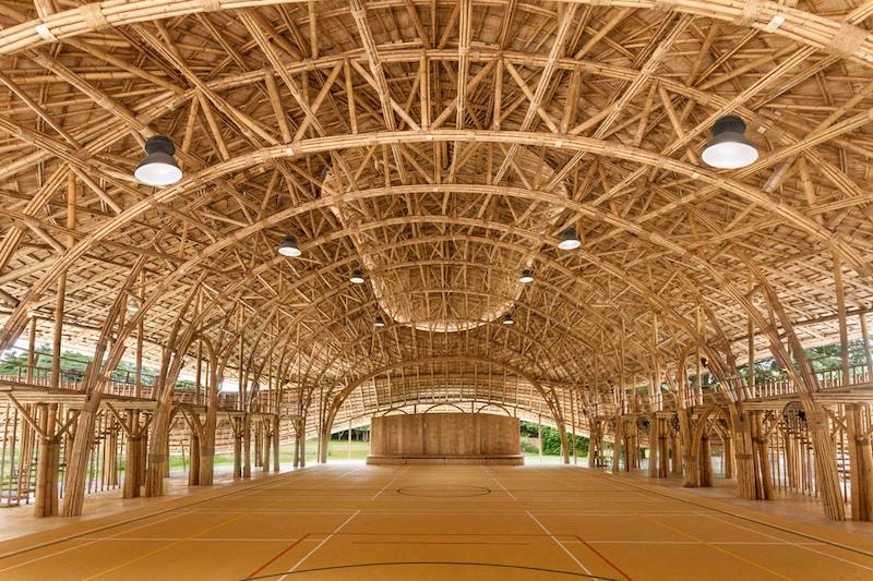 A large indoor sports hall with a bamboo frame structure.