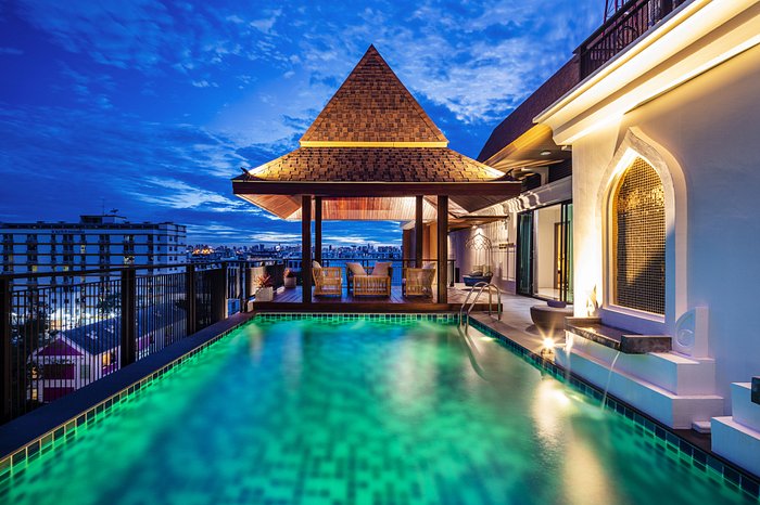 Traditional Thai sala with a swimming pool and a view of the city at night.