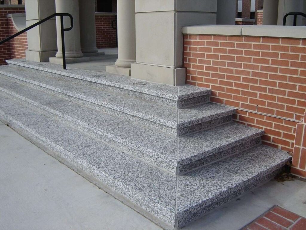 Stone granite stairs leading to the entrance of a building.