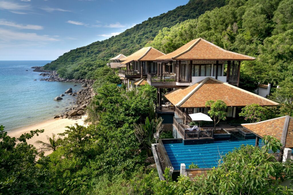 An eco-friendly villa in Koh Samui, surrounded by lush greenery, featuring sustainable materials like bamboo and solar panels.
